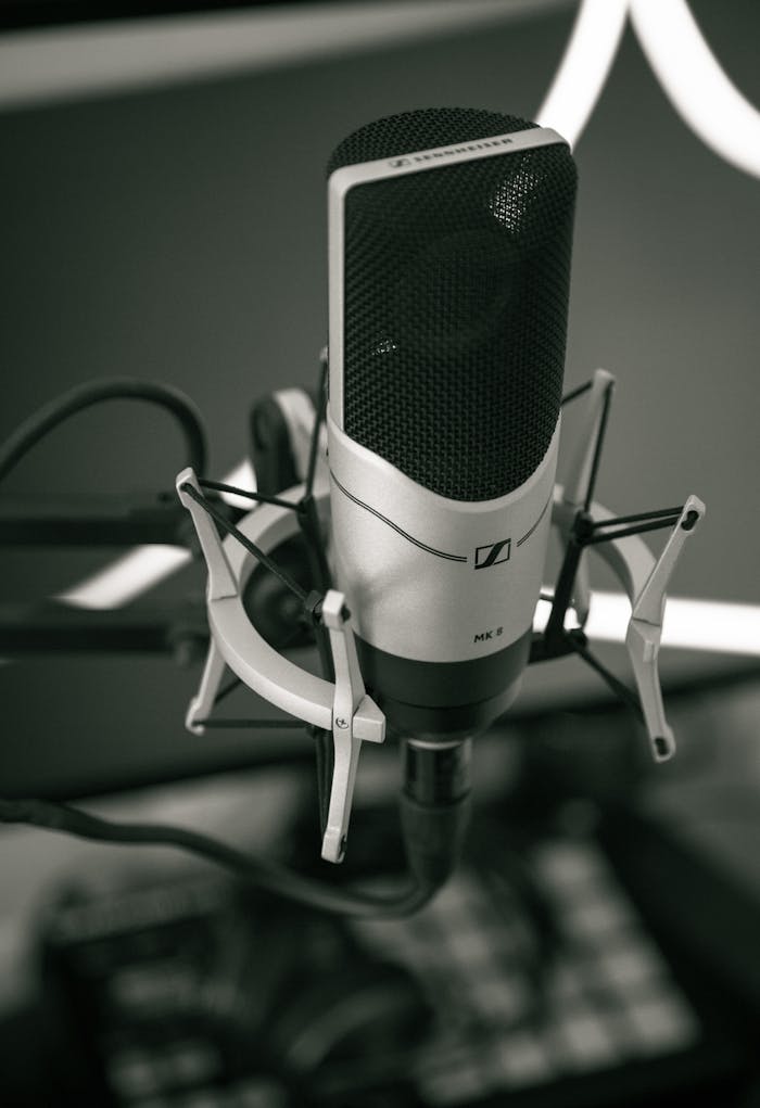 services-img Close-up of a sleek microphone setup in a modern recording studio, capturing sound with precision.